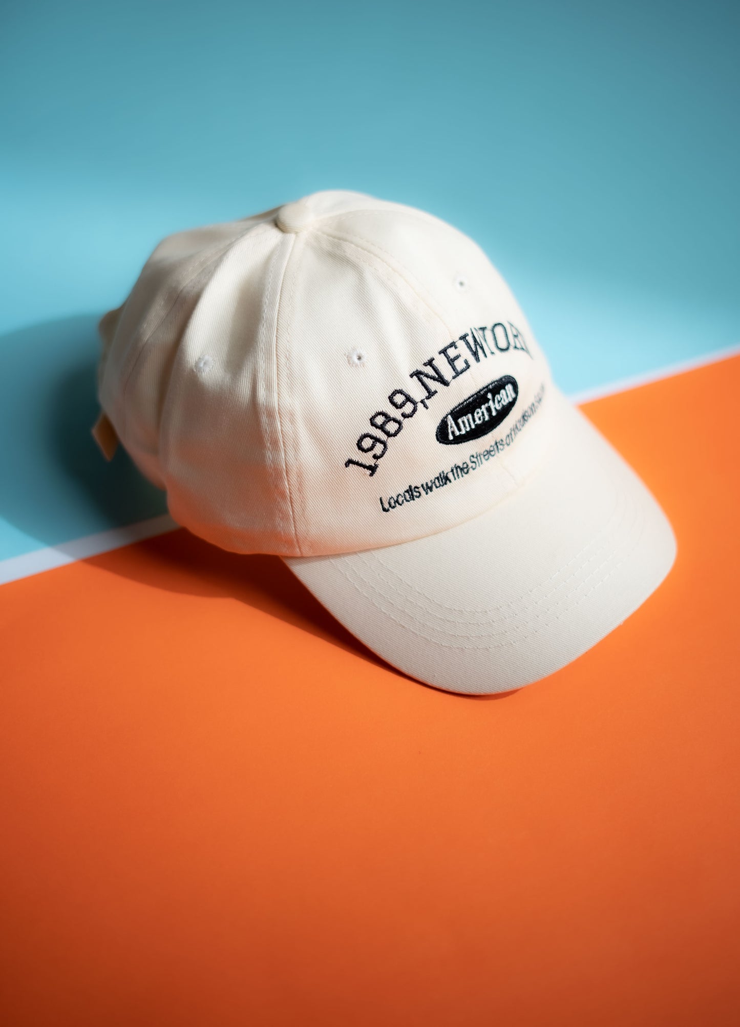 White cap with text on an orange and blue background in Pakistan by Caps Nation