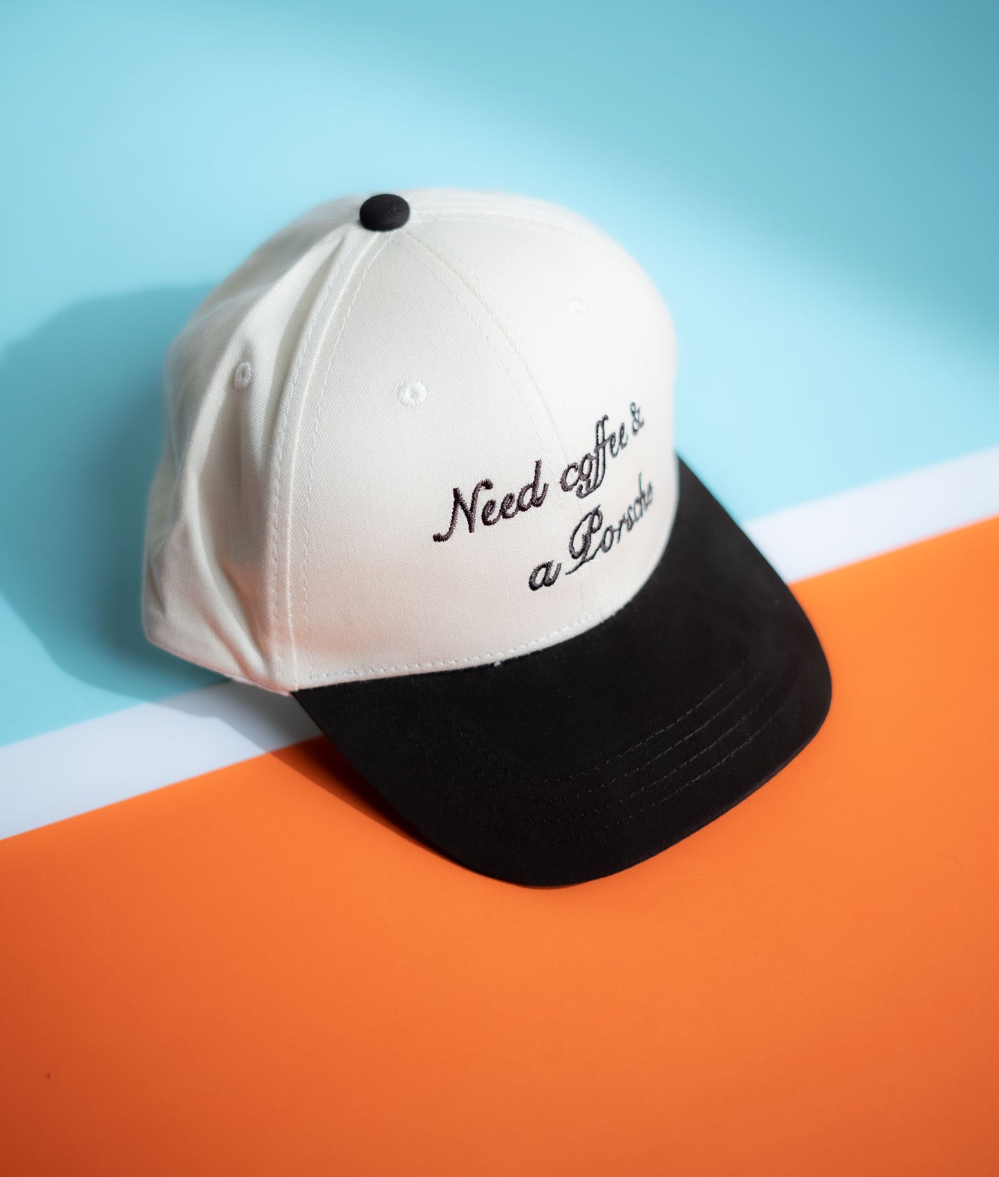 White and black cap with text on a blue and orange background in Pakistan by Caps Nation