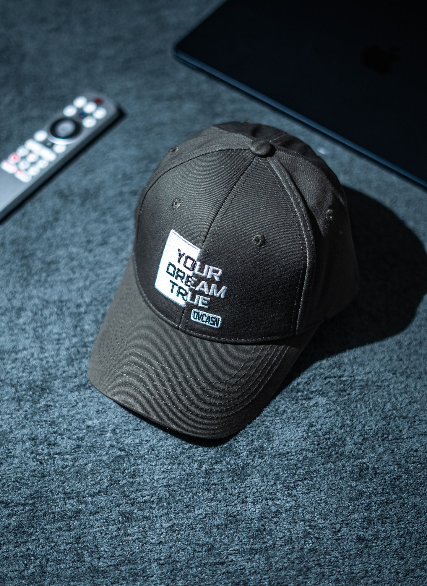 Black cap with 'Your Dream True' text on a dark textured surface in Pakistan by Caps Nation