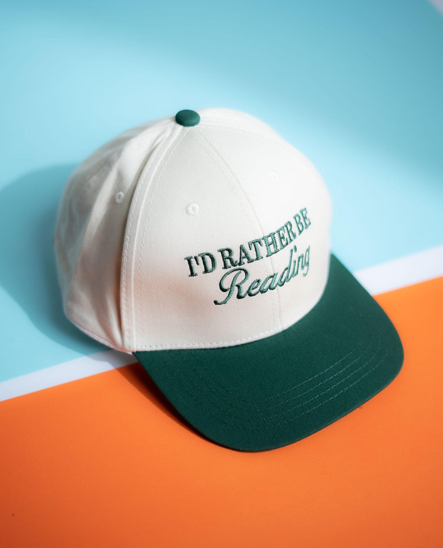 Cap with 'I'd Rather Be Reading' text on a orange background in Pakistan by Caps Nation