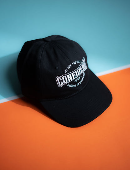 Black cap with white text on a blue and orange background in Pakistan by Caps Nation