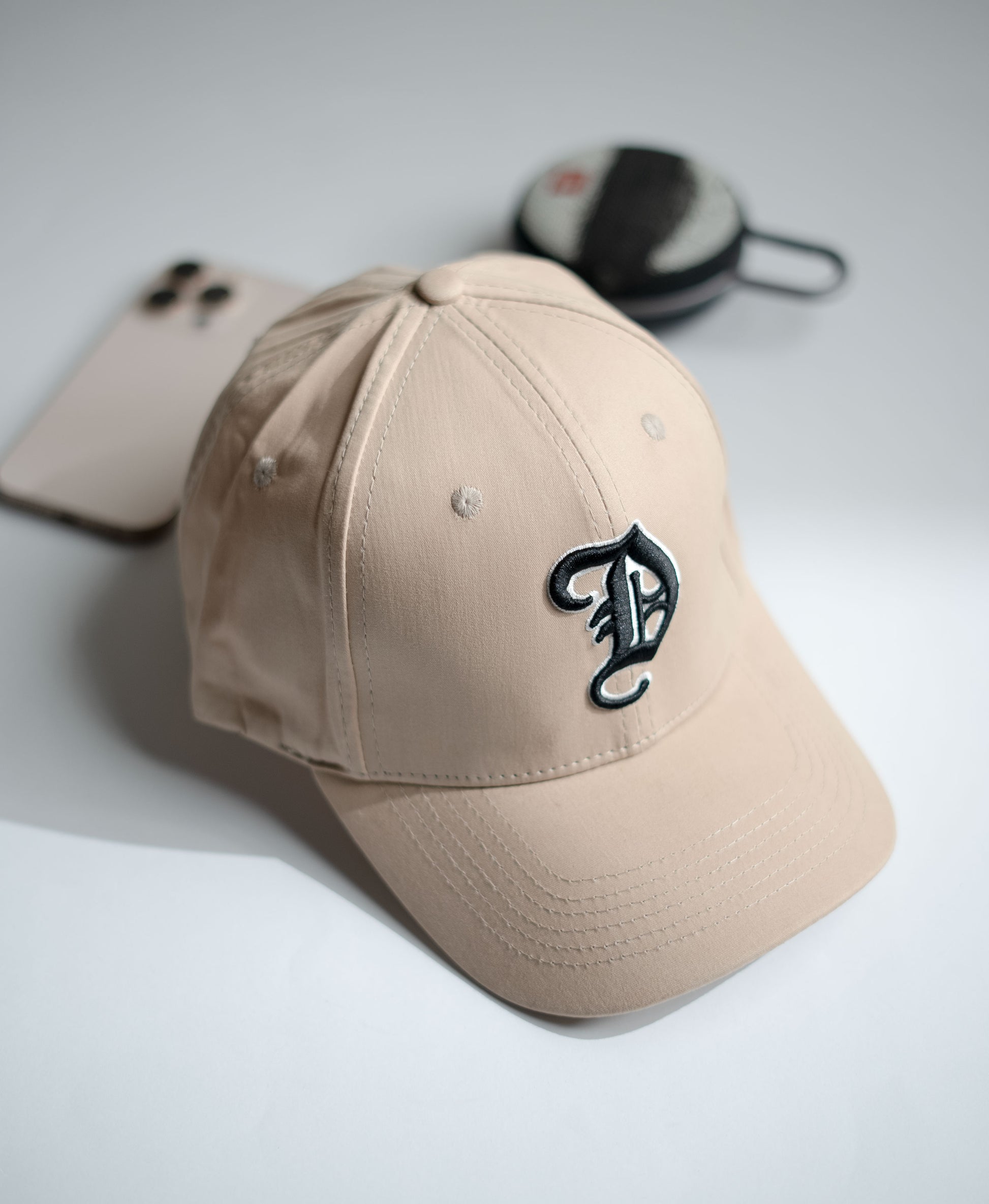 Beige cap with a logo on a light gray background in Pakistan by Caps Nation