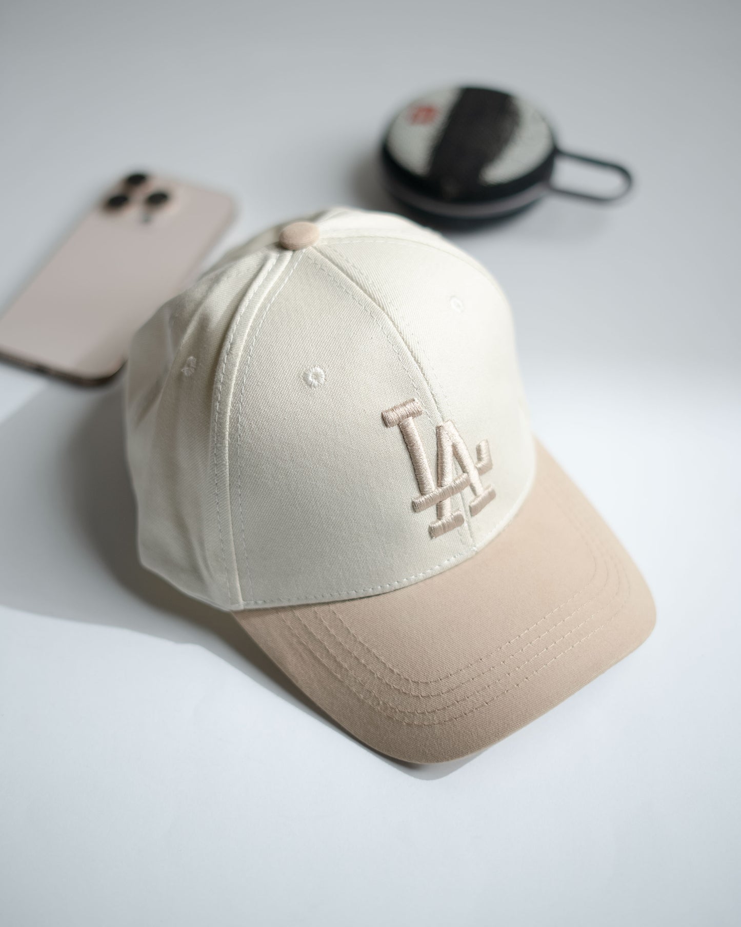 Beige baseball cap with logo on a light gray surface in Pakistan by Caps Nation