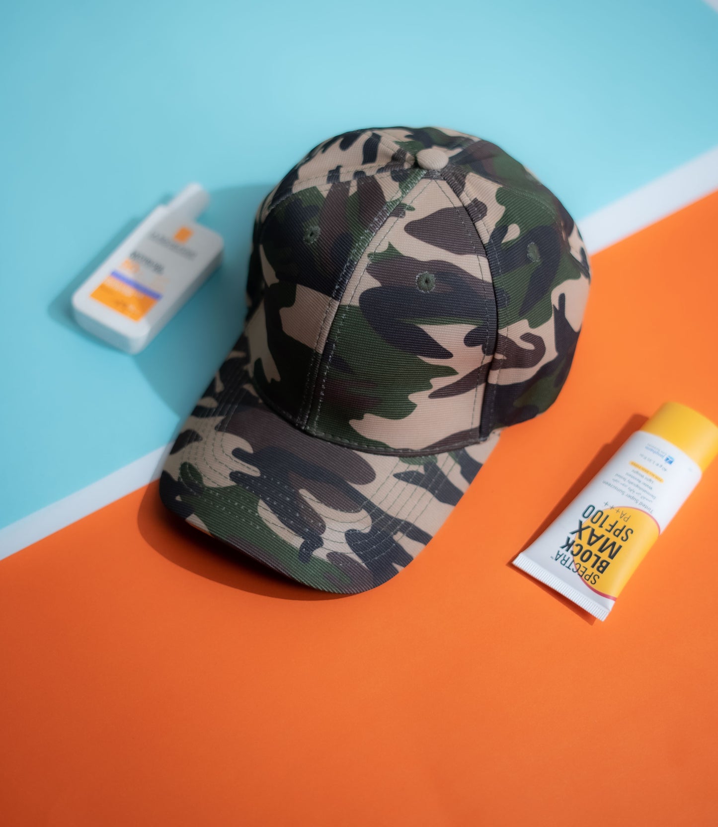 Camouflage cap and sunscreen bottles on a colorful background in Pakistan by Caps Nation