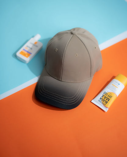Brown cap on an orange and blue surface with sunscreen bottles in Pakistan by Caps Nation