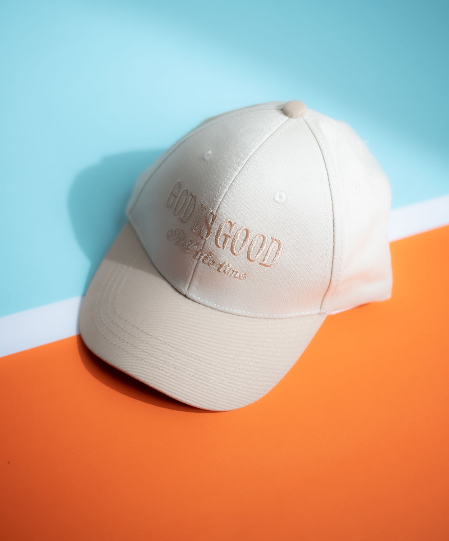 Beige cap with text on an orange and blue background in Pakistan by Caps Nation
