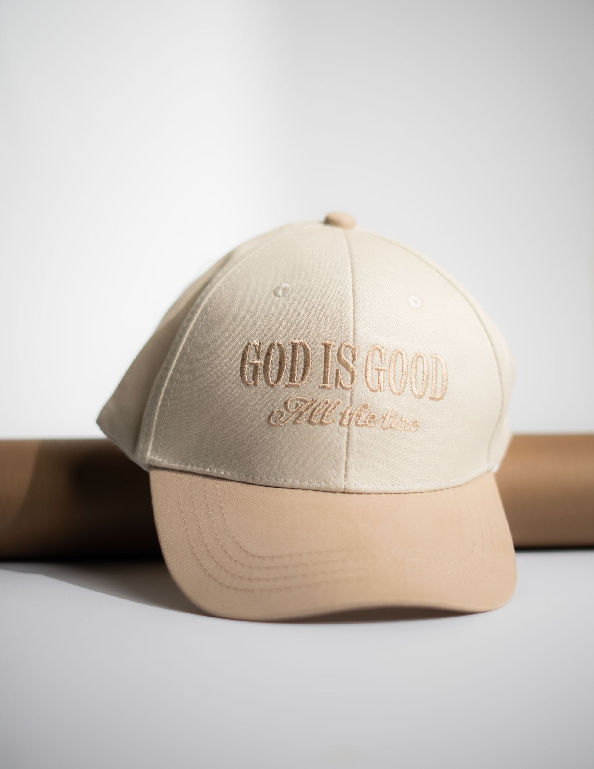 Beige cap with 'God is Good All the Time' text on a light gray background in Pakistan by Caps Nation