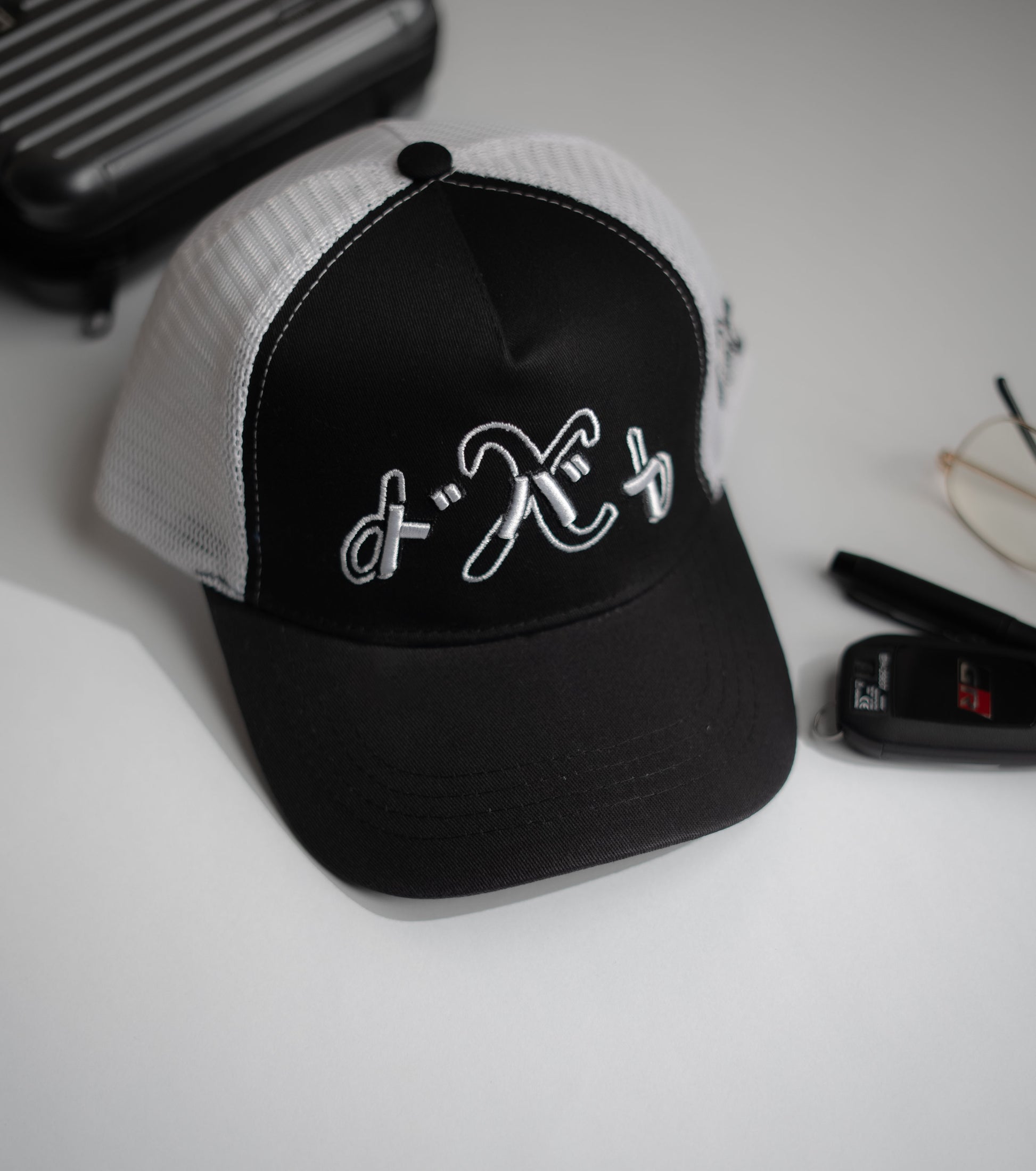 Black and white cap with a logo on a light surface in Pakistan by Caps Nation