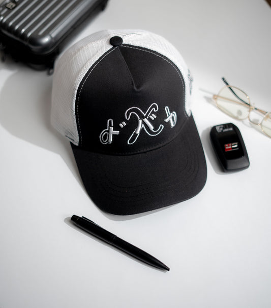 Black and white cap with a logo on a white surface with a pen and phone in Pakistan by Caps Nation