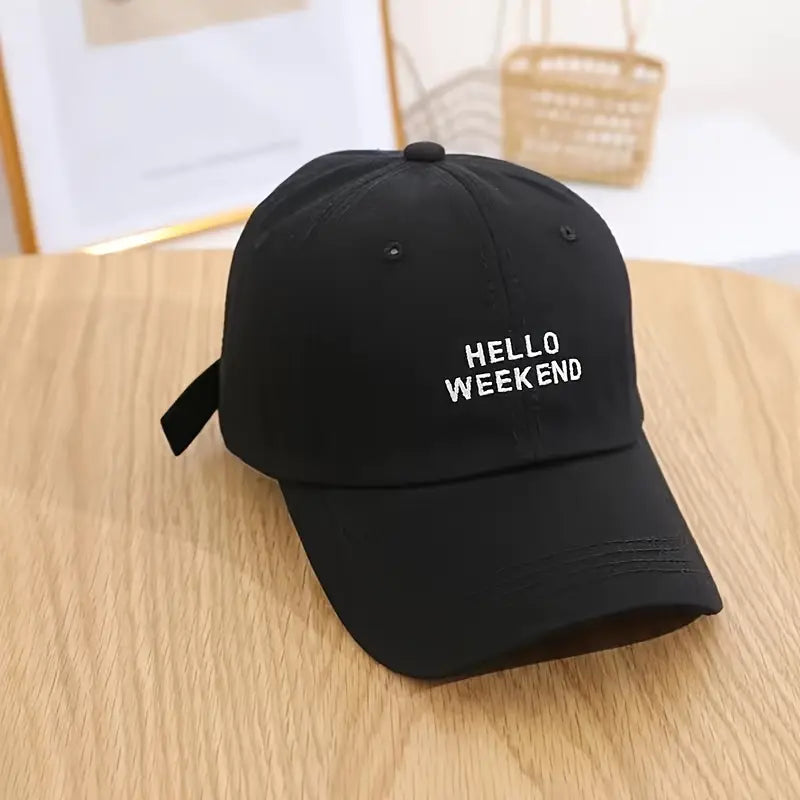 Black cap with 'HELLO WEEKEND' text on a wooden table in Pakistan by Caps Nation