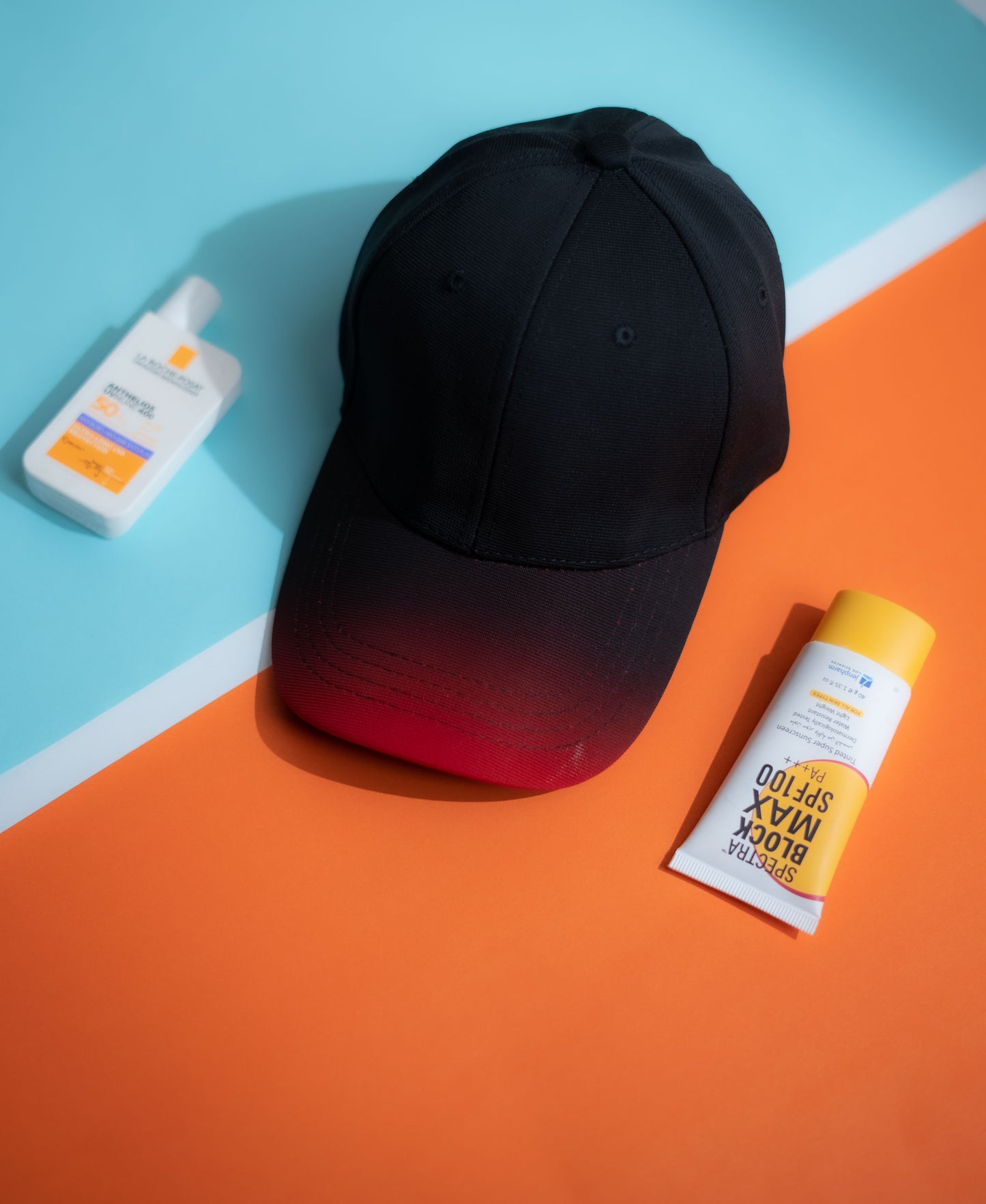 Black cap and sunscreen bottles on a colorful geometric background in Pakistan by Caps Nation