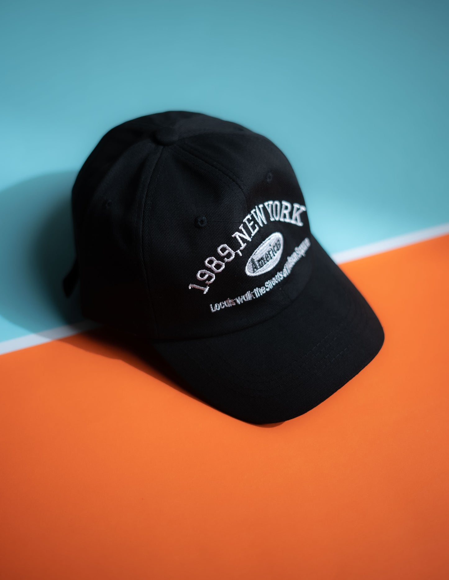 Black cap with '1989, New York' text on a blue and orange background in Pakistan by Caps Nation