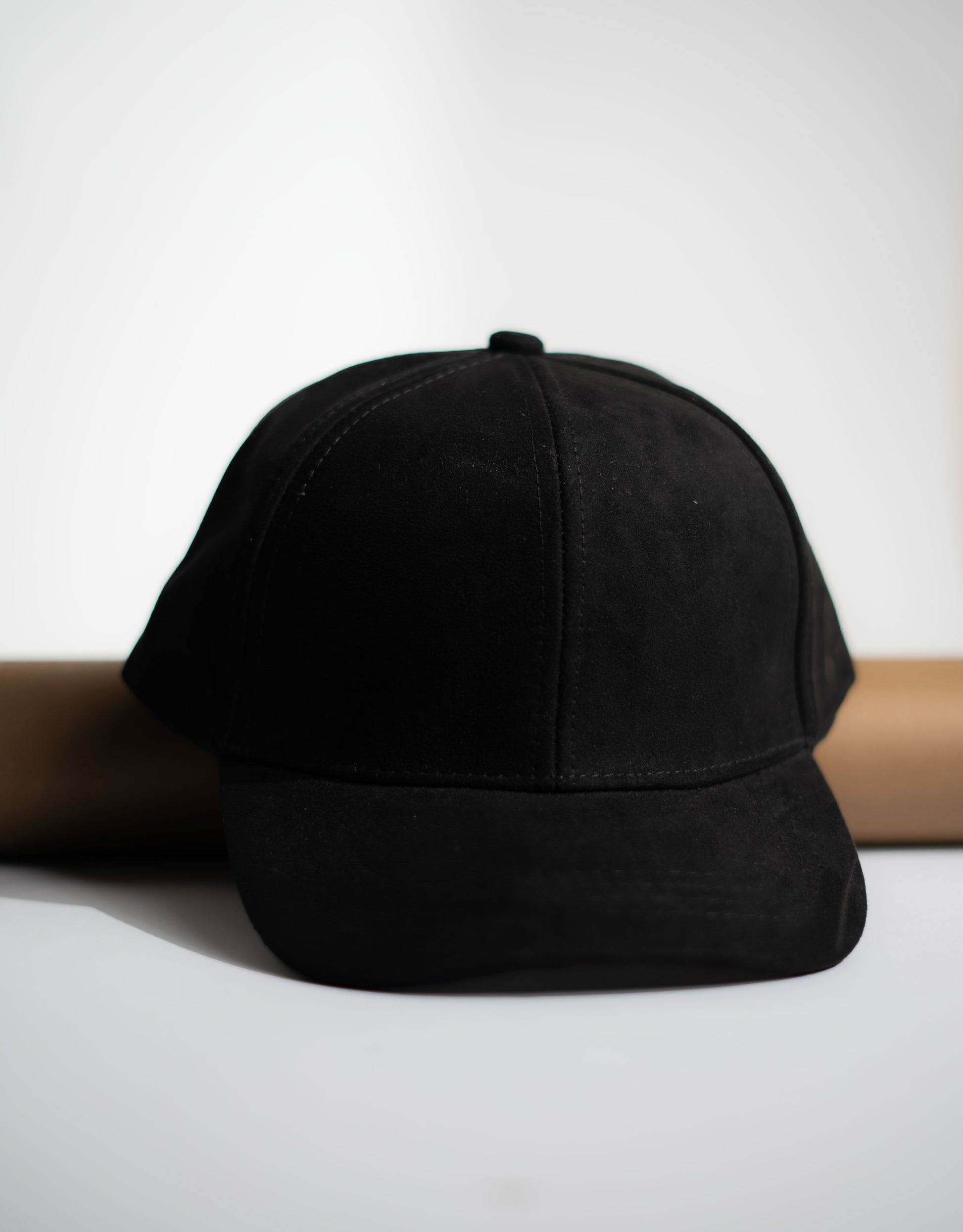 Black cap on a white surface with a neutral background in Pakistan by Caps Nation