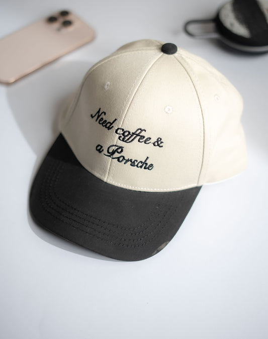 Beige and black cap with 'Need coffee & a Porsche' text on a light gray background in Pakistan by Caps Nation