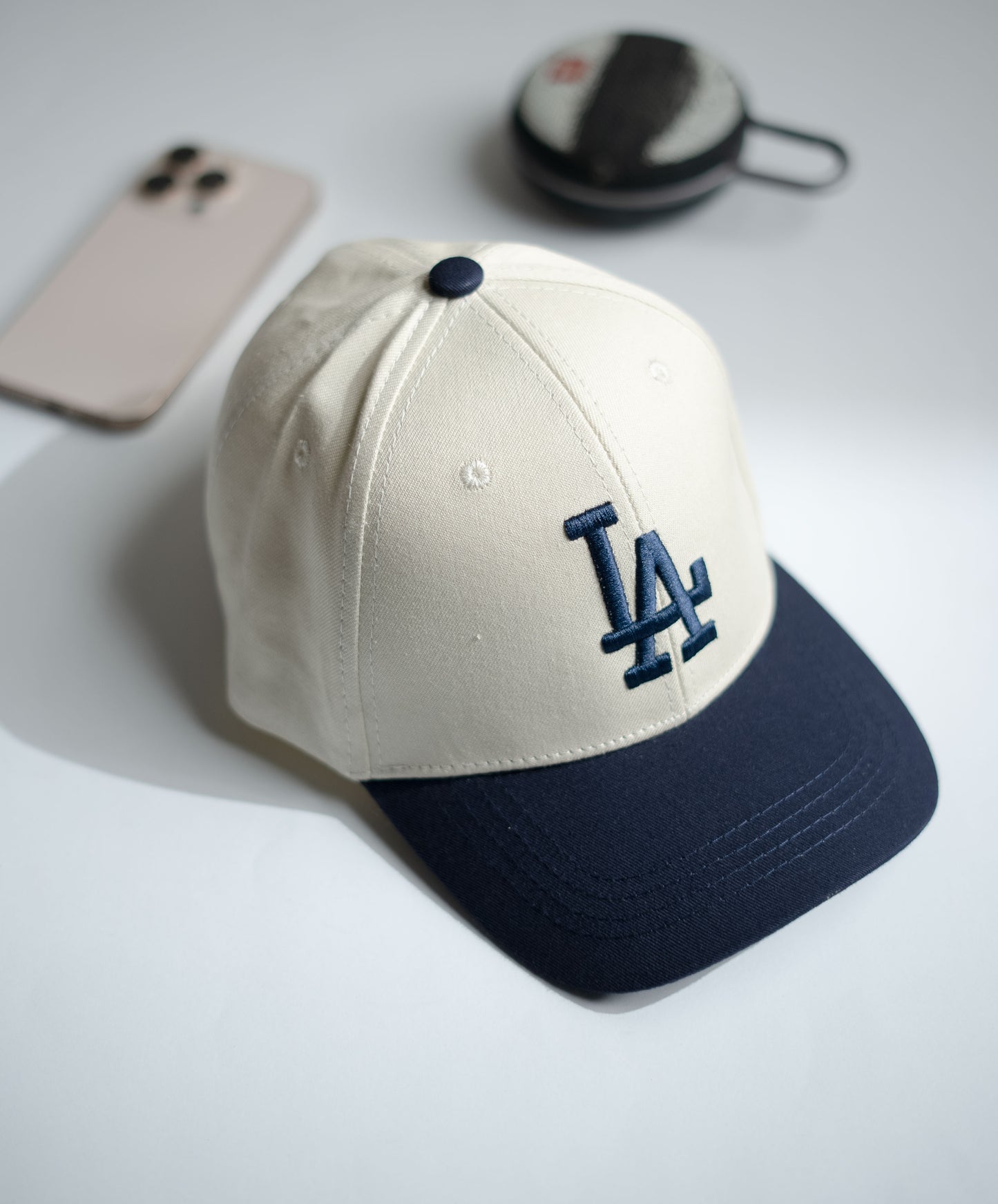 Beige and navy baseball cap with LA logo on a light gray surface in Pakistan by Caps Nation