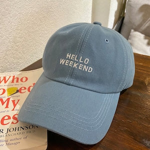 Blue cap with 'Hello Weekend' text on a wooden surface in Pakistan by Caps Nation