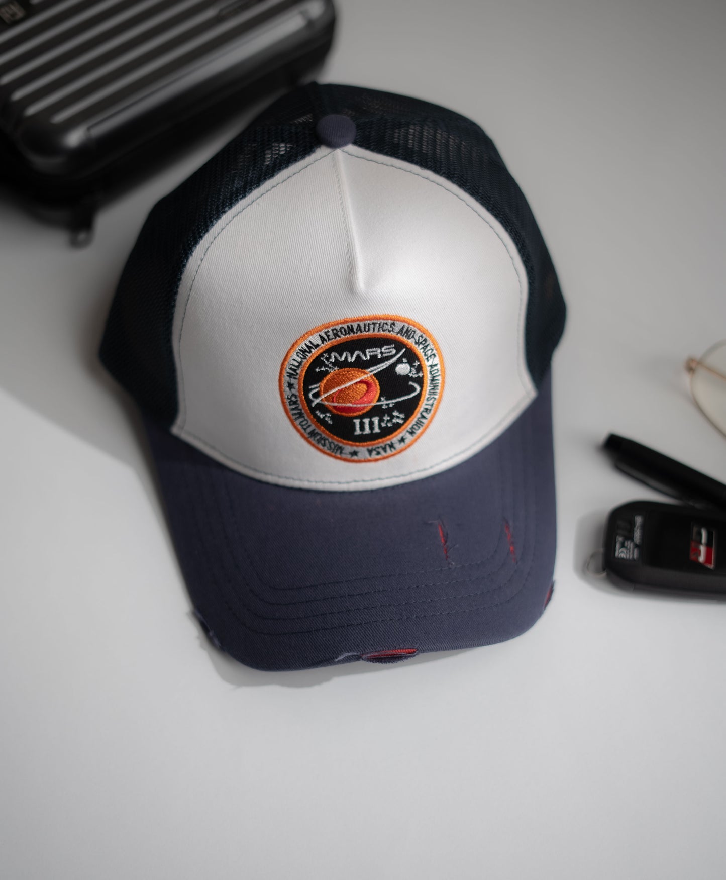 Navy and white cap with a logo on a light gray surface in Pakistan by Caps Nation