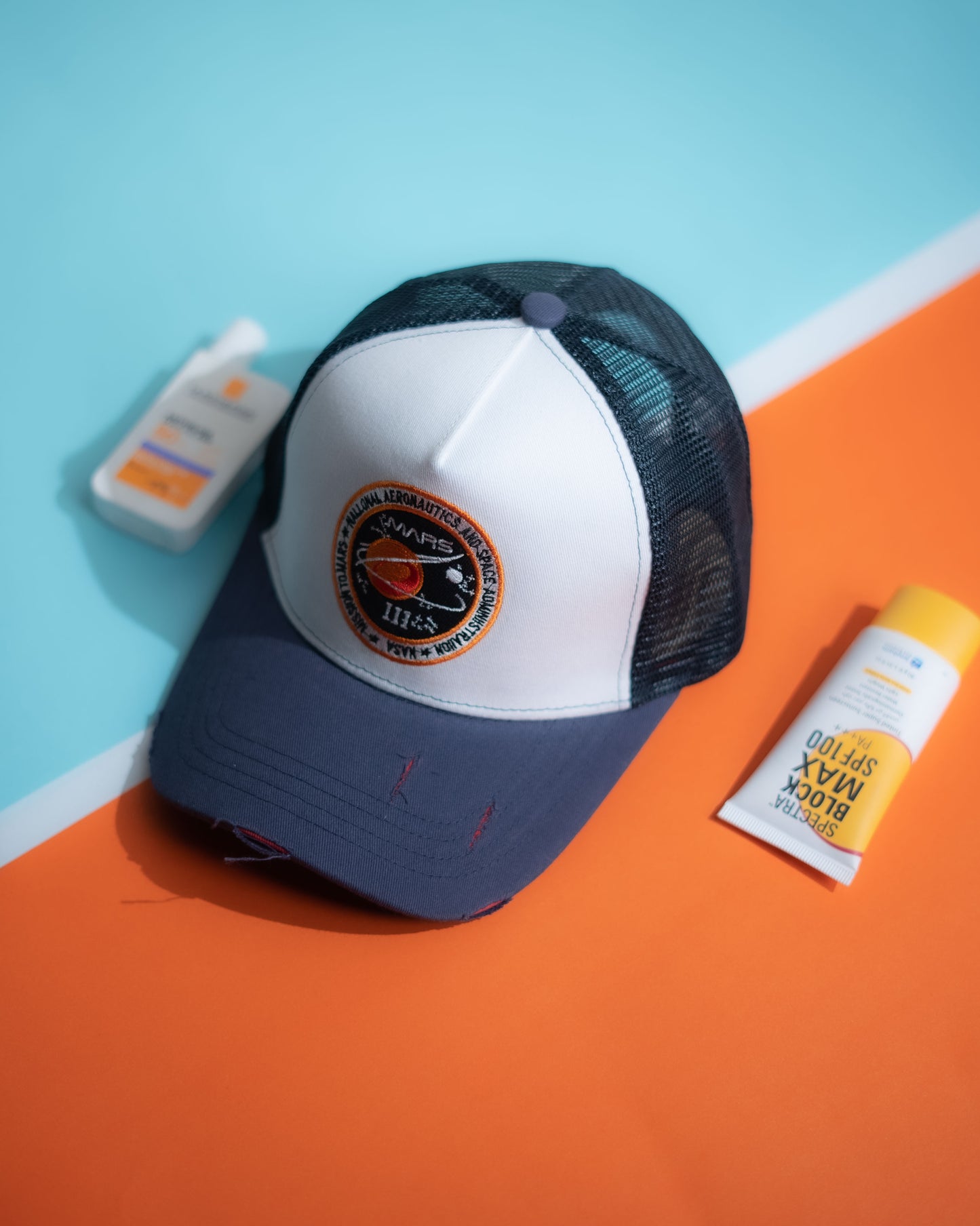 Trucker hat with a logo on an orange and blue background in Pakistan by Caps Nation