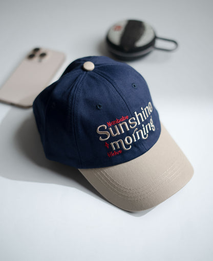 Navy blue cap with 'Sunshine Morning' text on a light gray surface in Pakistan by Caps Nation