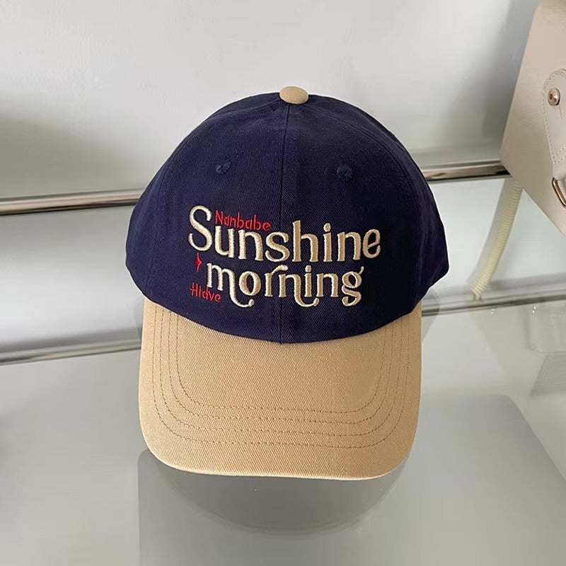 Navy and beige cap with 'Sunshine morning' text on a reflective surface in Pakistan by Caps Nation