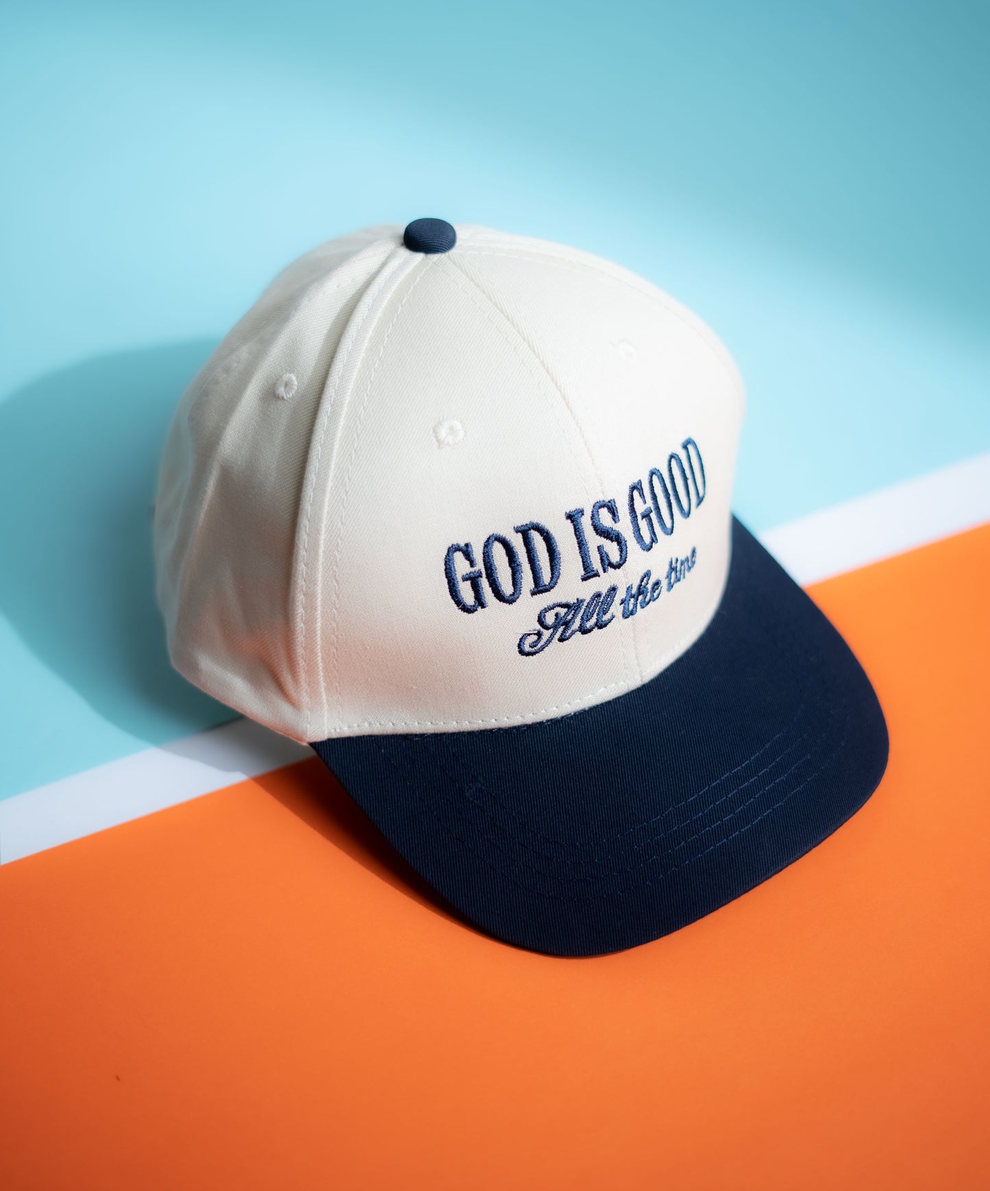Cap with 'GOD IS GOOD All the Time' text on a blue and orange background in Pakistan by Caps Nation