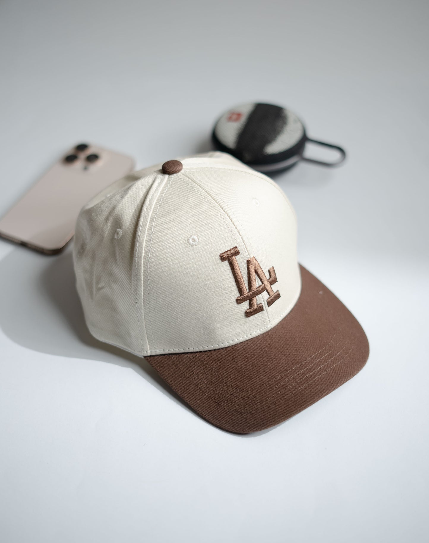 Beige and brown baseball cap with LA logo on a light gray surface in Pakistan by Caps Nation