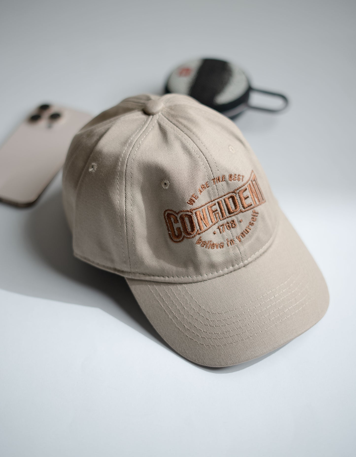 Beige cap with embroidered text on a light gray background in Pakistan by Caps Nation