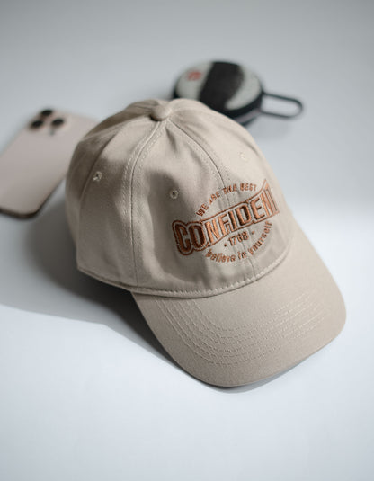 Beige cap with embroidered text on a light gray background in Pakistan by Caps Nation