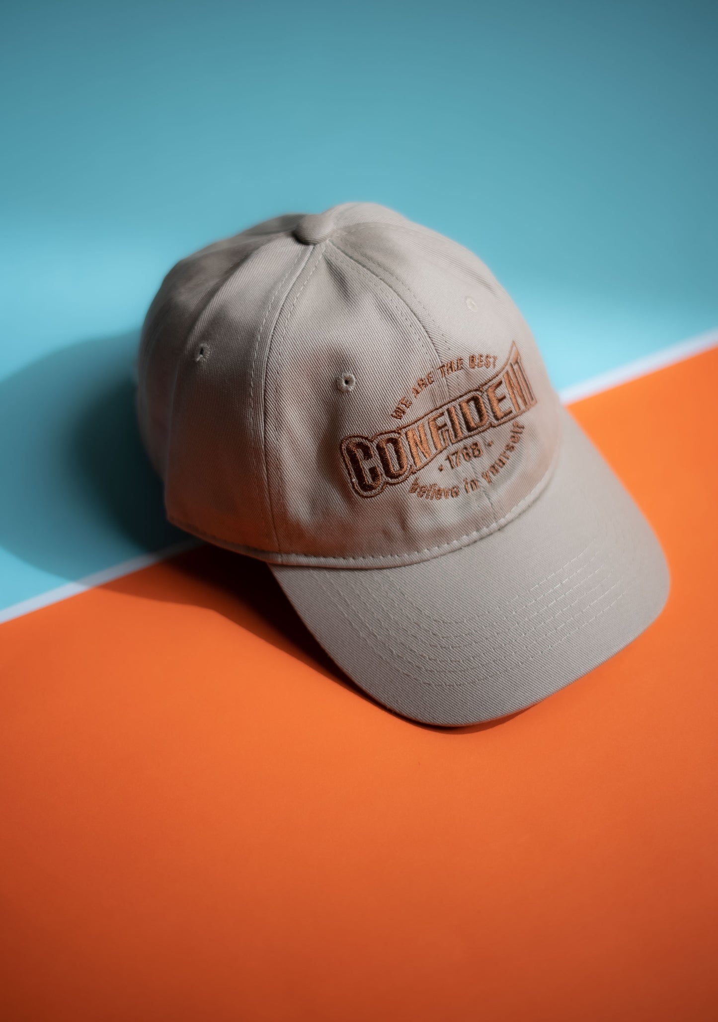 Beige cap with text on a blue and orange background in Pakistan by Caps Nation