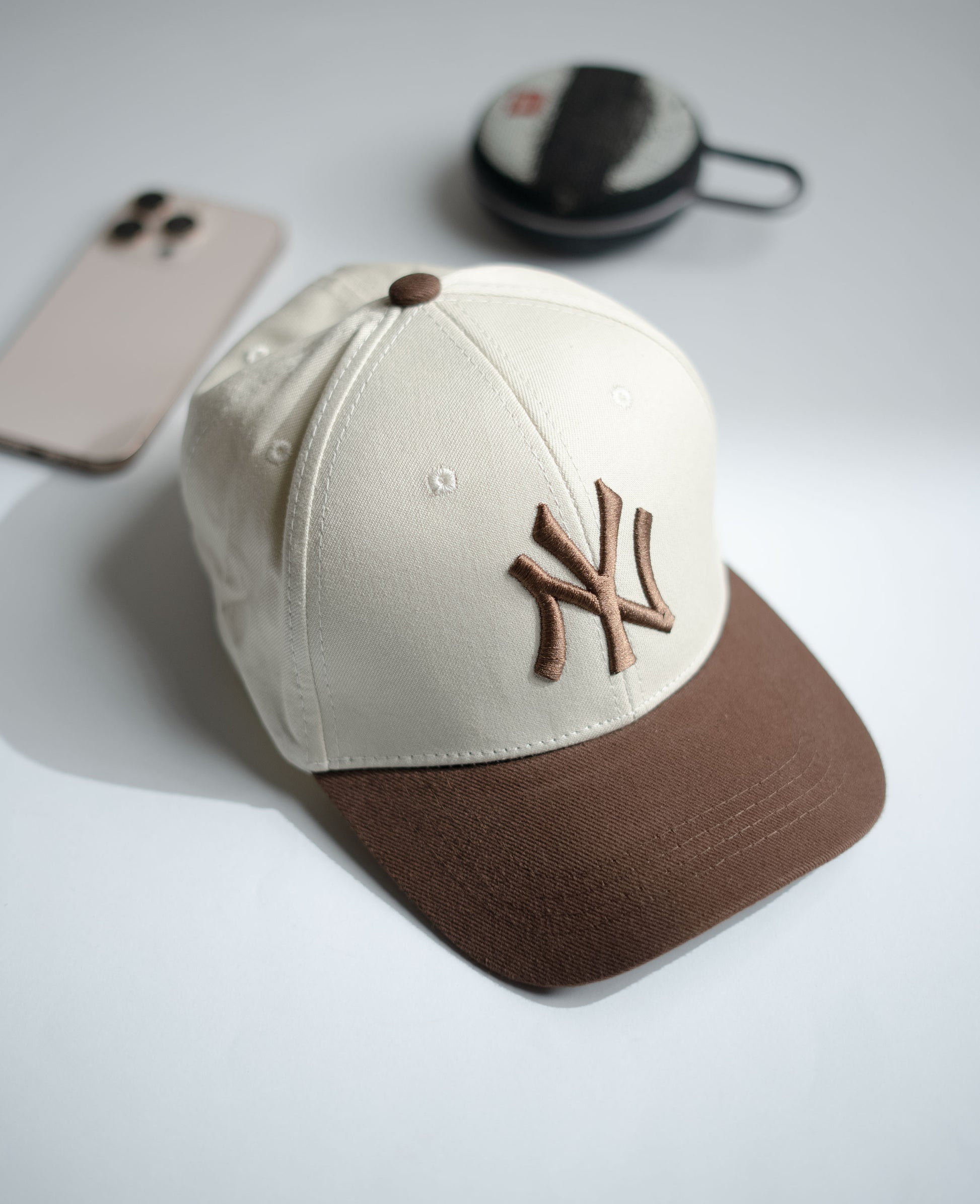 Baseball cap with brown and beige design on a light gray surface in Pakistan by Caps Nation