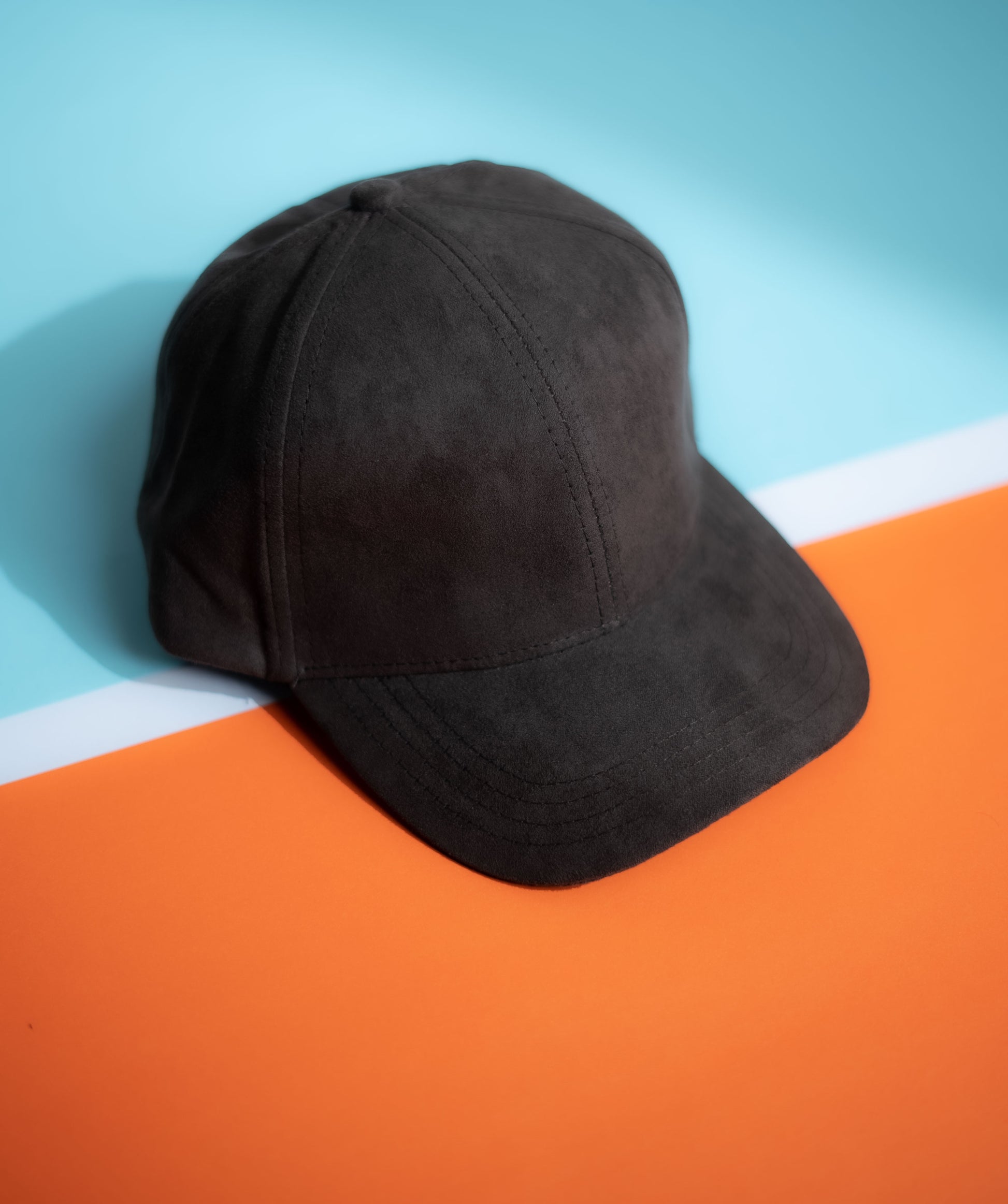Black cap on a blue and orange gradient background in Pakistan by Caps Nation