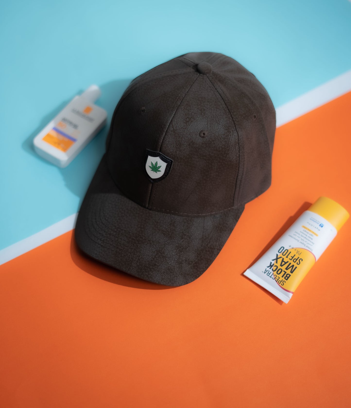 Dark brown cap with a logo on an orange and blue background in Pakistan by Caps Nation