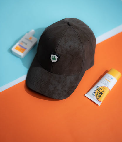 Dark brown cap with a logo on an orange and blue background in Pakistan by Caps Nation