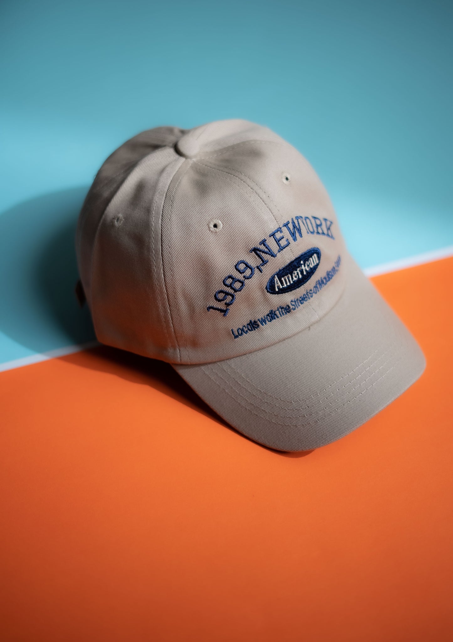 Beige cap with text on a blue and orange background in Pakistan by Caps Nation