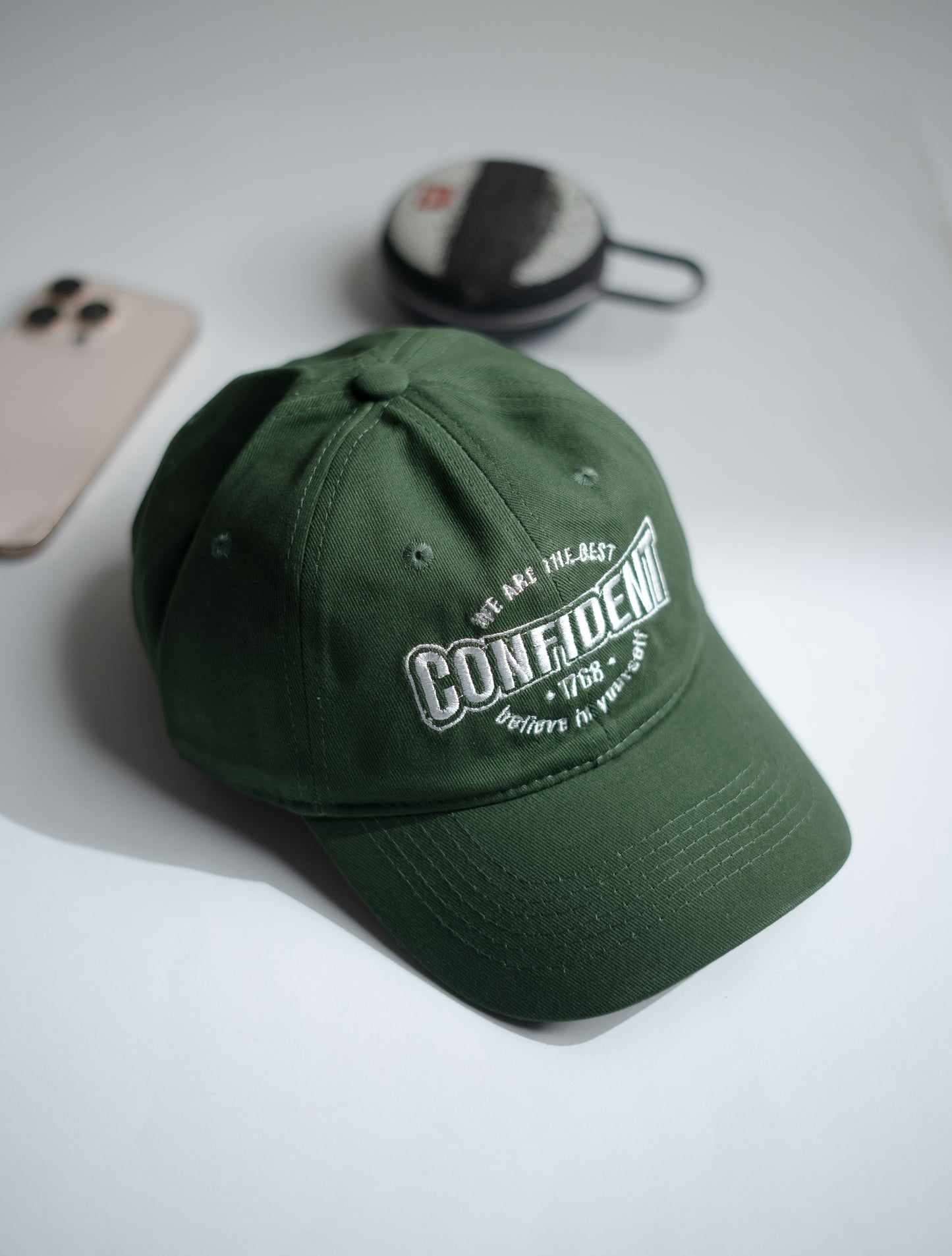 Green cap with text on a light gray surface in Pakistan by Caps Nation