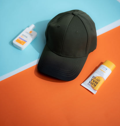 Green cap and sunscreen bottles on a blue and orange background in Pakistan by Caps Nation
