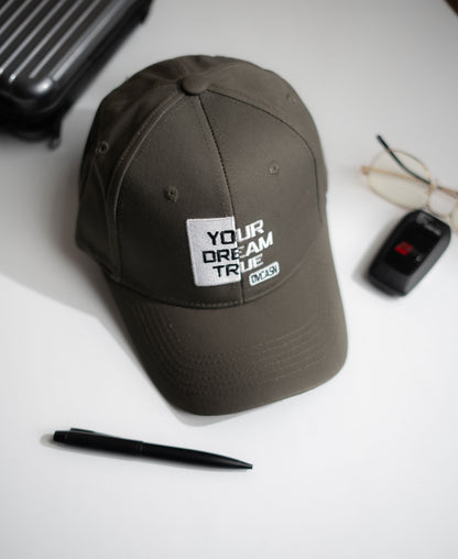Brown cap with motivational text on a white surface with a pen and car keys in Pakistan by Caps Nation