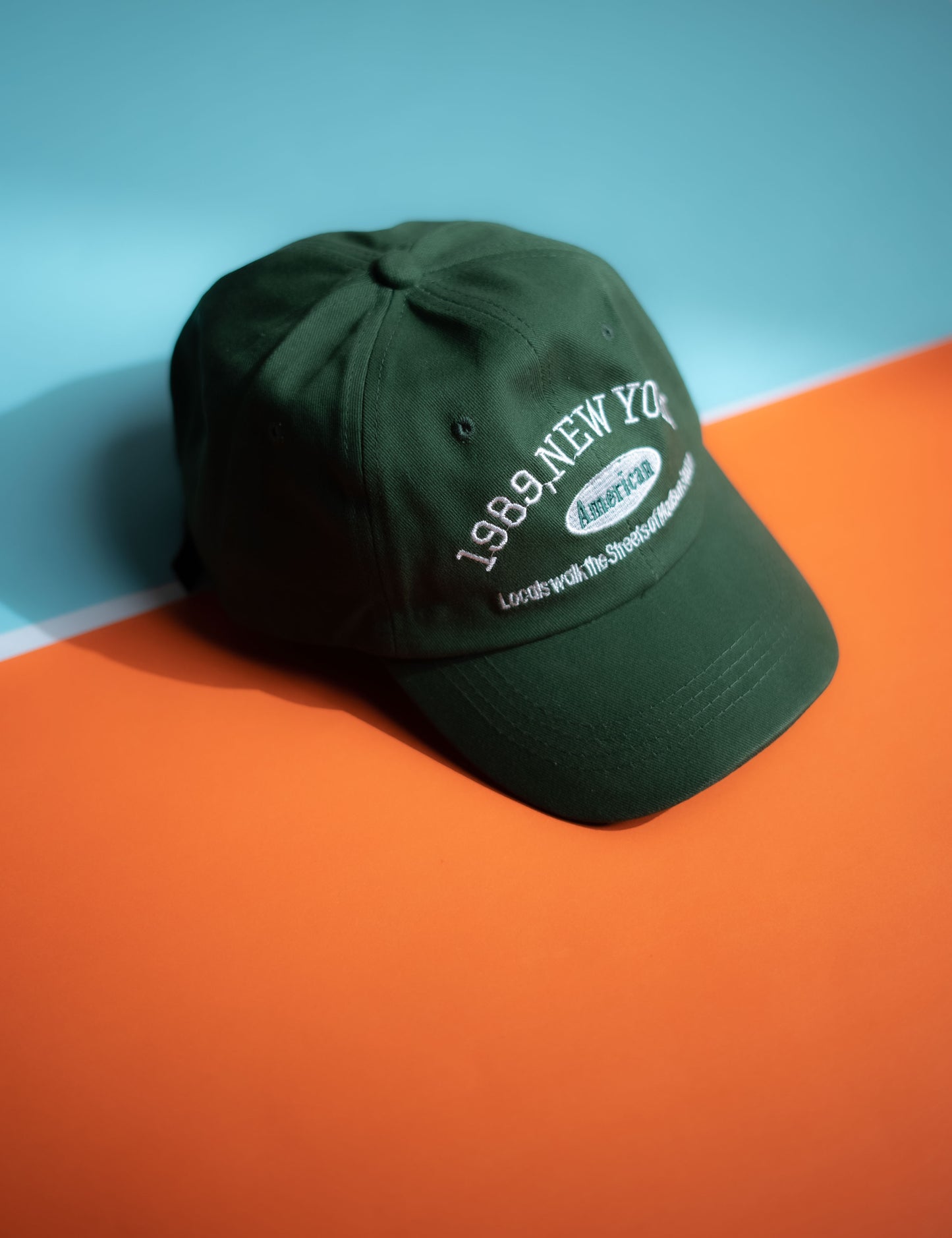 Green cap with text on an orange and blue background in Pakistan by Caps Nation