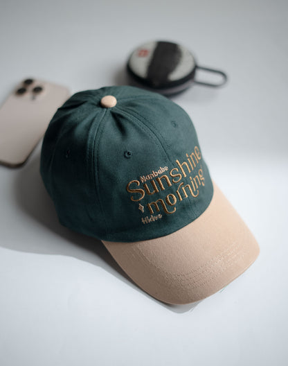 Green and beige cap with embroidered text on a light gray surface in Pakistan by Caps Nation