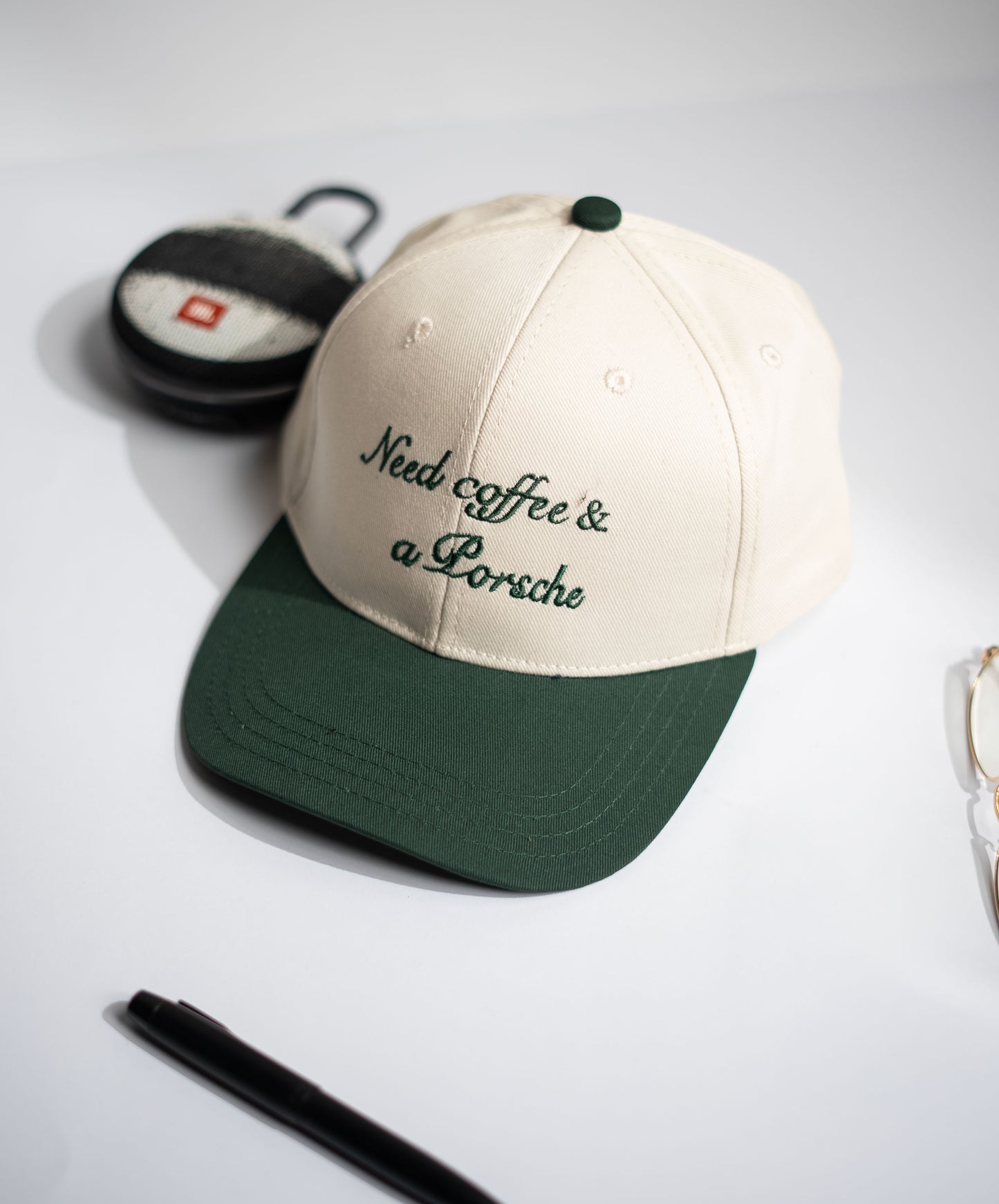 Cap with 'Need coffee & a Porsche' text on a neutral background in Pakistan by Caps Nation