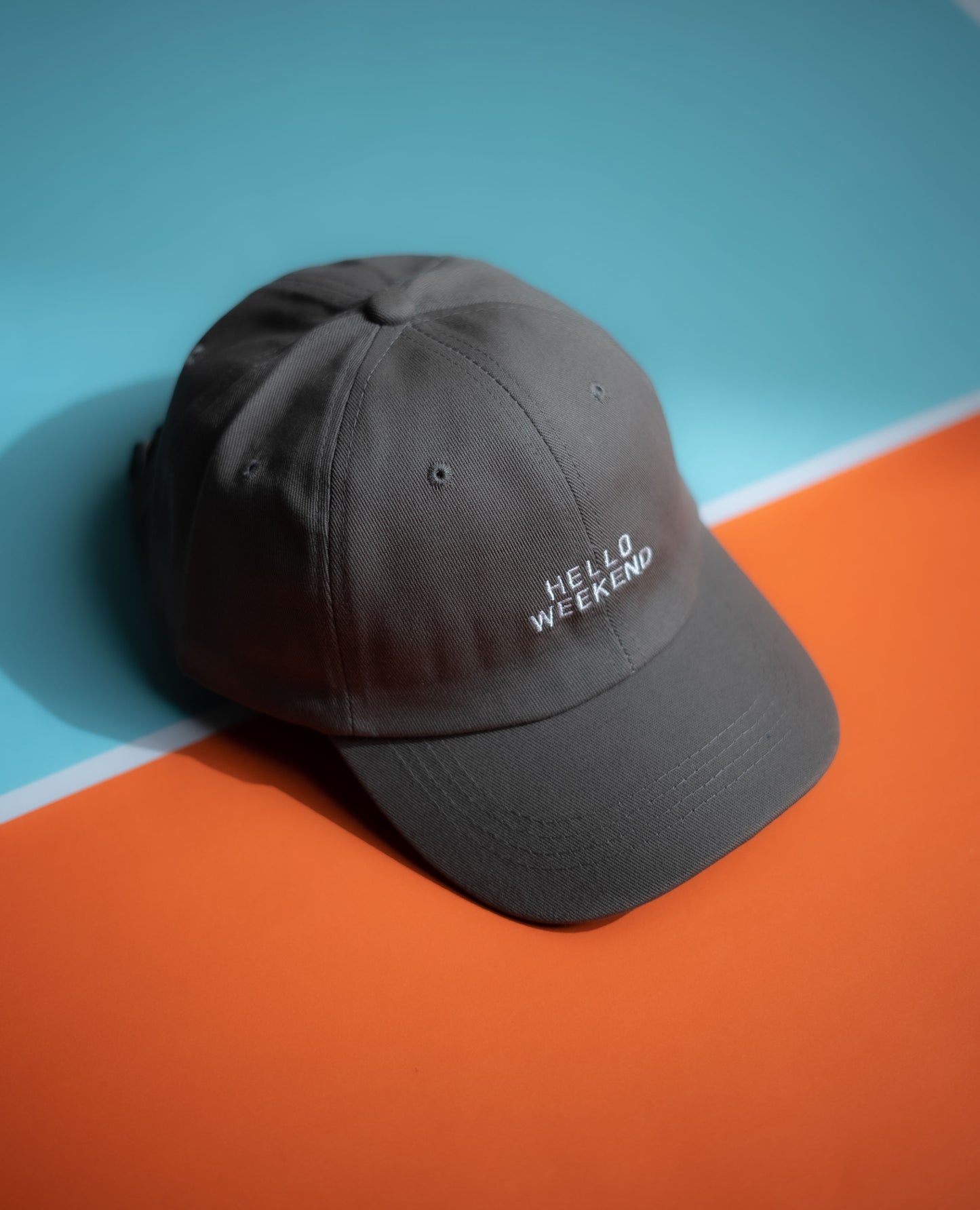 Gray cap with 'Hello Weekend' text on a blue and orange background  in Pakistan by Caps Nation