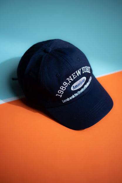 Navy blue cap with white text on an orange and blue background  in Pakistan by Caps Nation