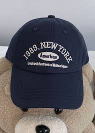 Black cap with text on a plush brown surface in Pakistan by Caps Nation