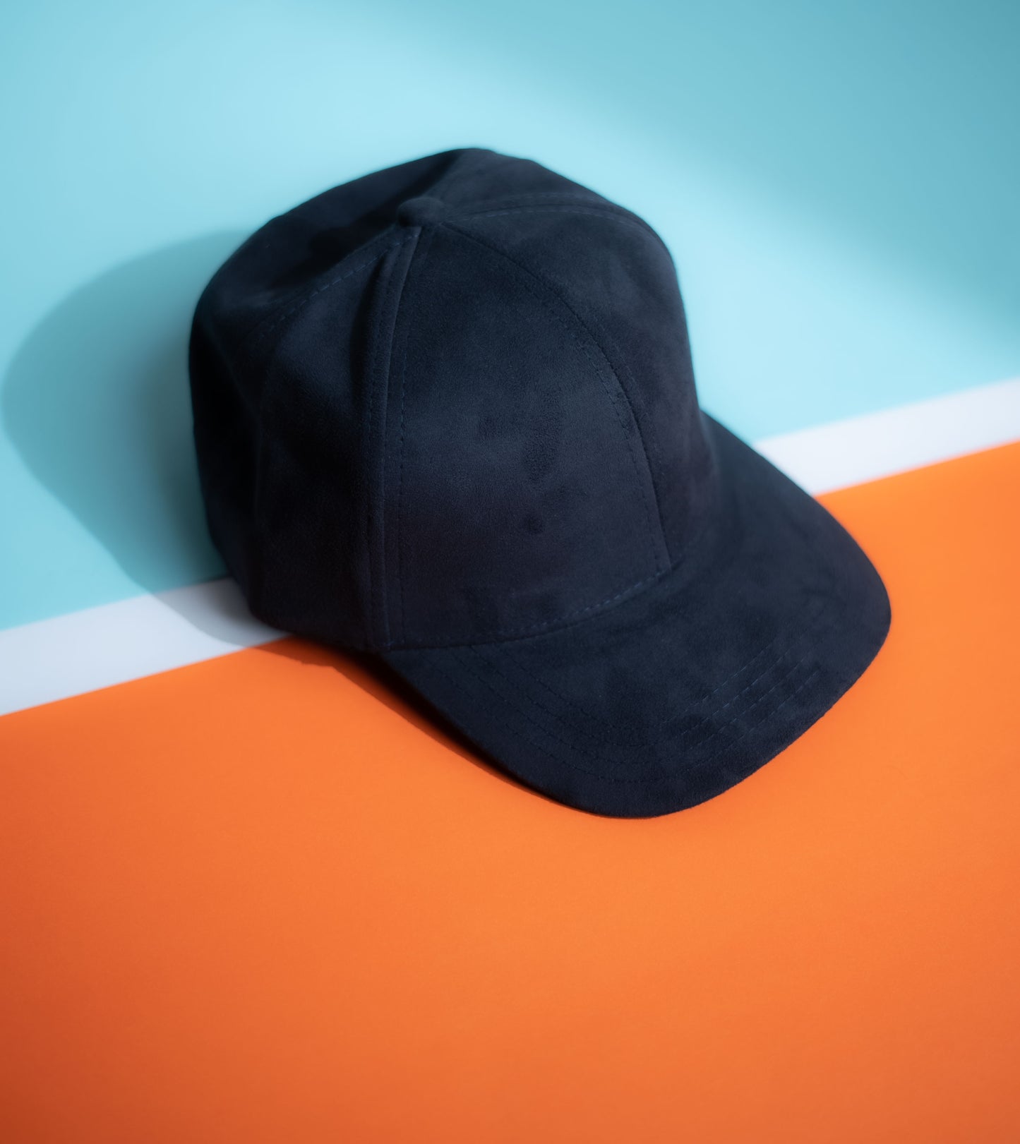 Black cap on an orange and blue background in Pakistan by Caps Nation