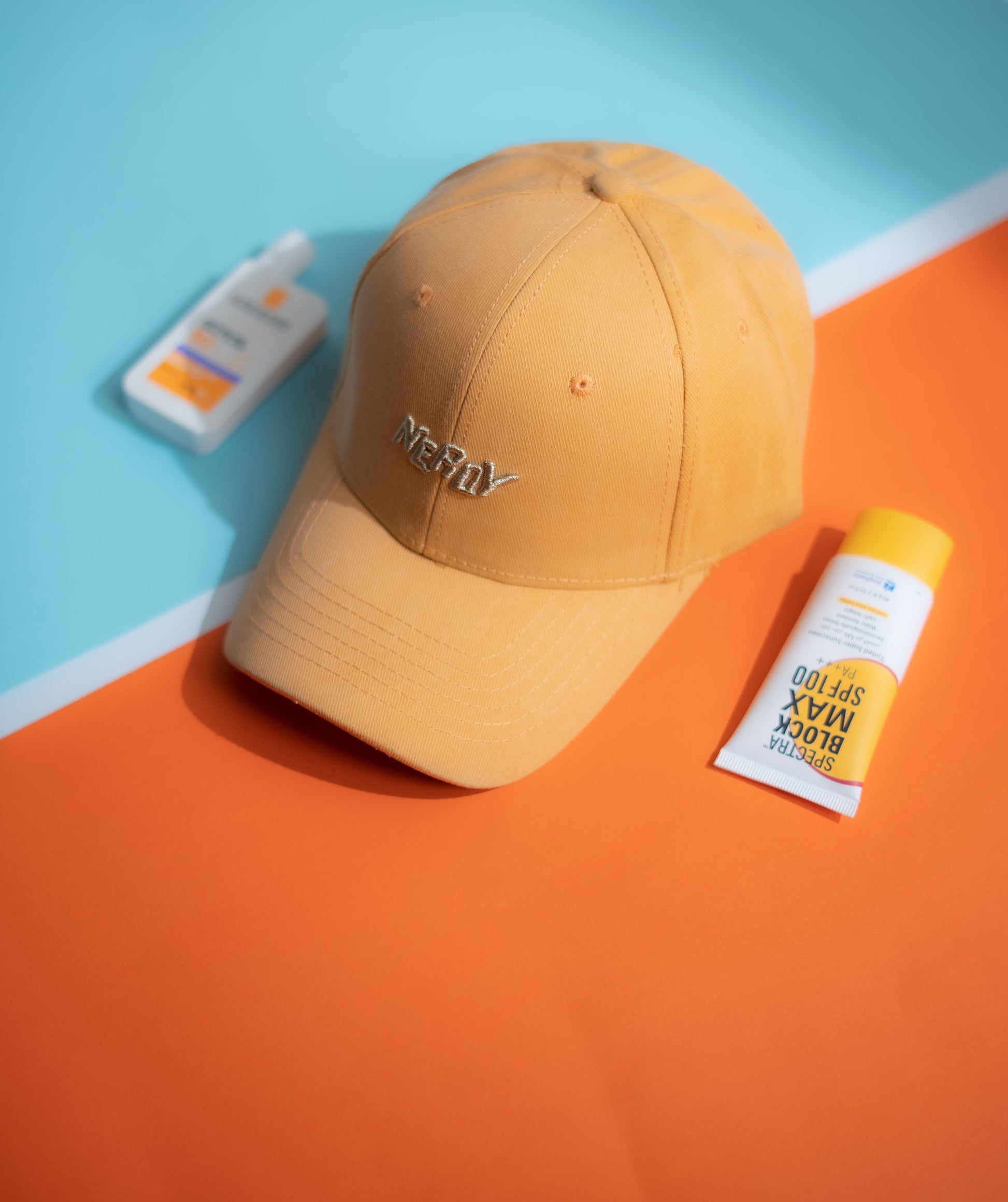 Brown cap with 'NERDY' branding on a blue and orange background in Pakistan by Caps Nation
