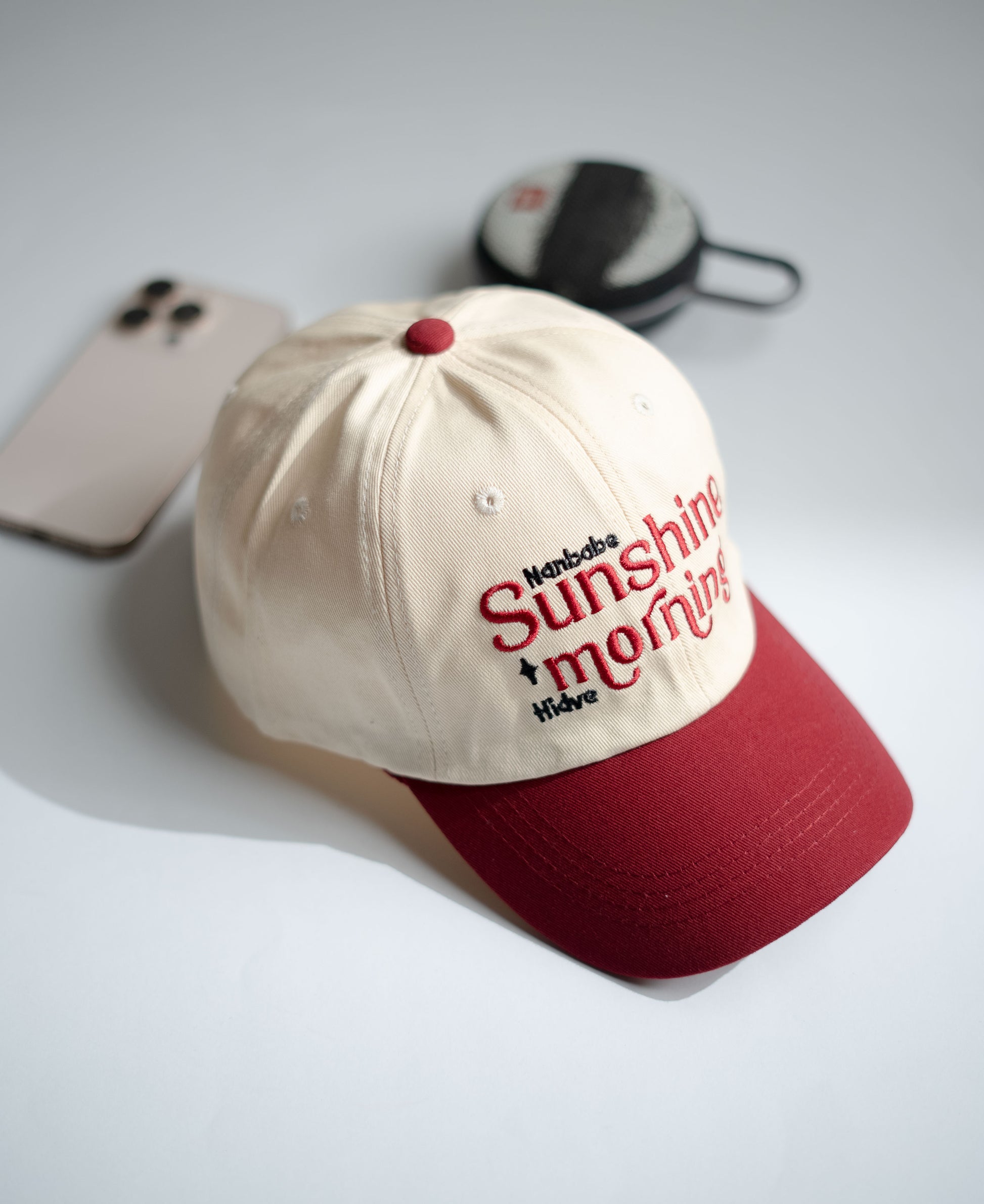Beige and red cap with text on a light gray surface in Pakistan by Caps Nation