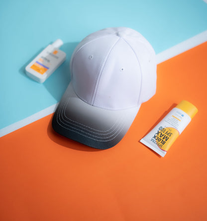 White cap and sunscreen bottles on a colorful geometric background 