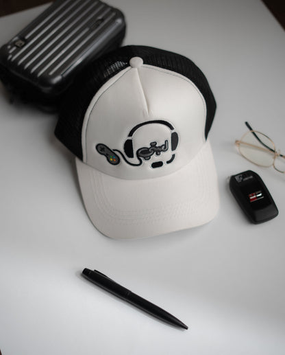 White cap with black logo on a white surface with a pen, glasses, and black case in Pakistan by Caps Nation