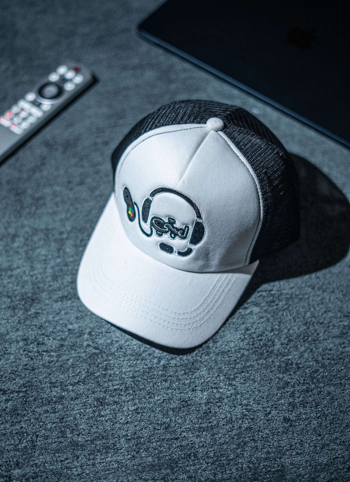 White cap with black brim and logo on a dark surface in Pakistan by Caps Nation