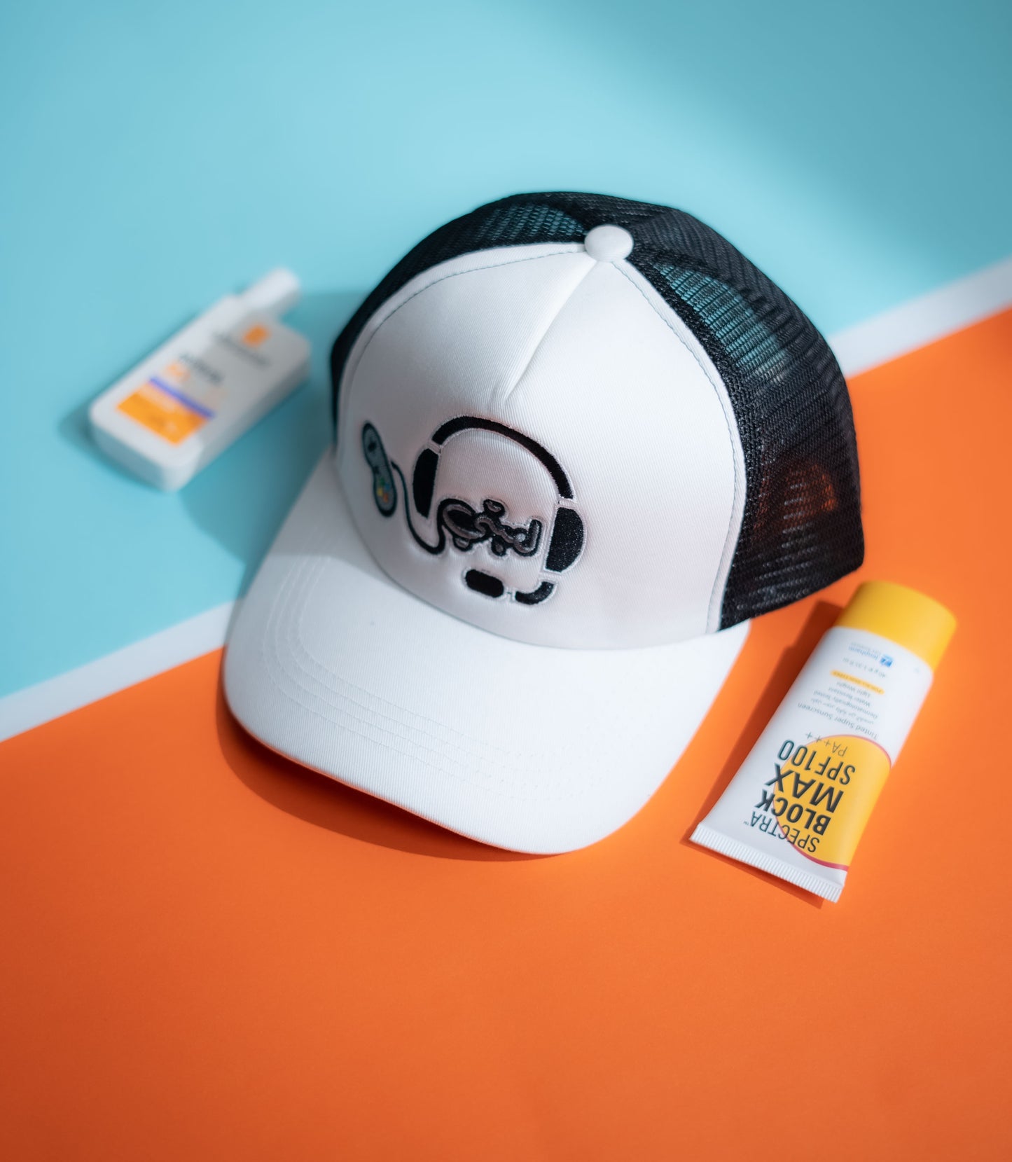 White cap with black mesh and dog design, placed on a blue and orange background with sunscreen bottles in Pakistan by Caps Nation